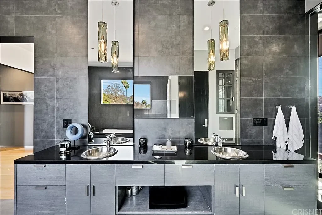 Faucets paired with vessel basins and a reflective countertop. — Villa Laurel