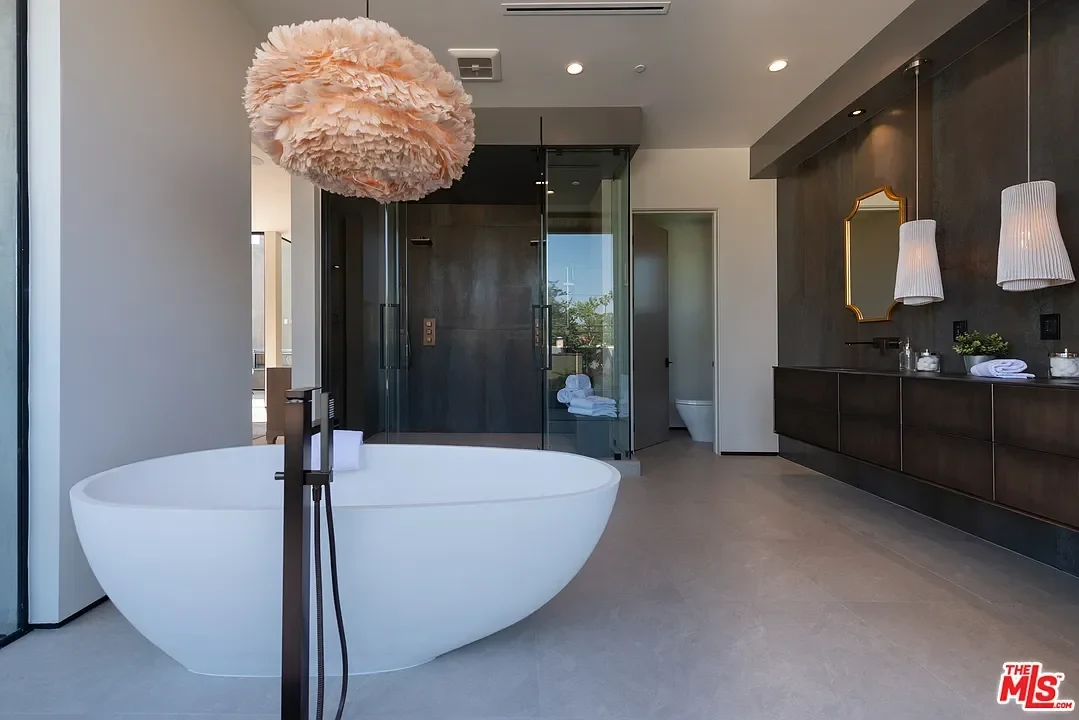 A sculptural pendant beside a freestanding bath. — La Dulce Vida