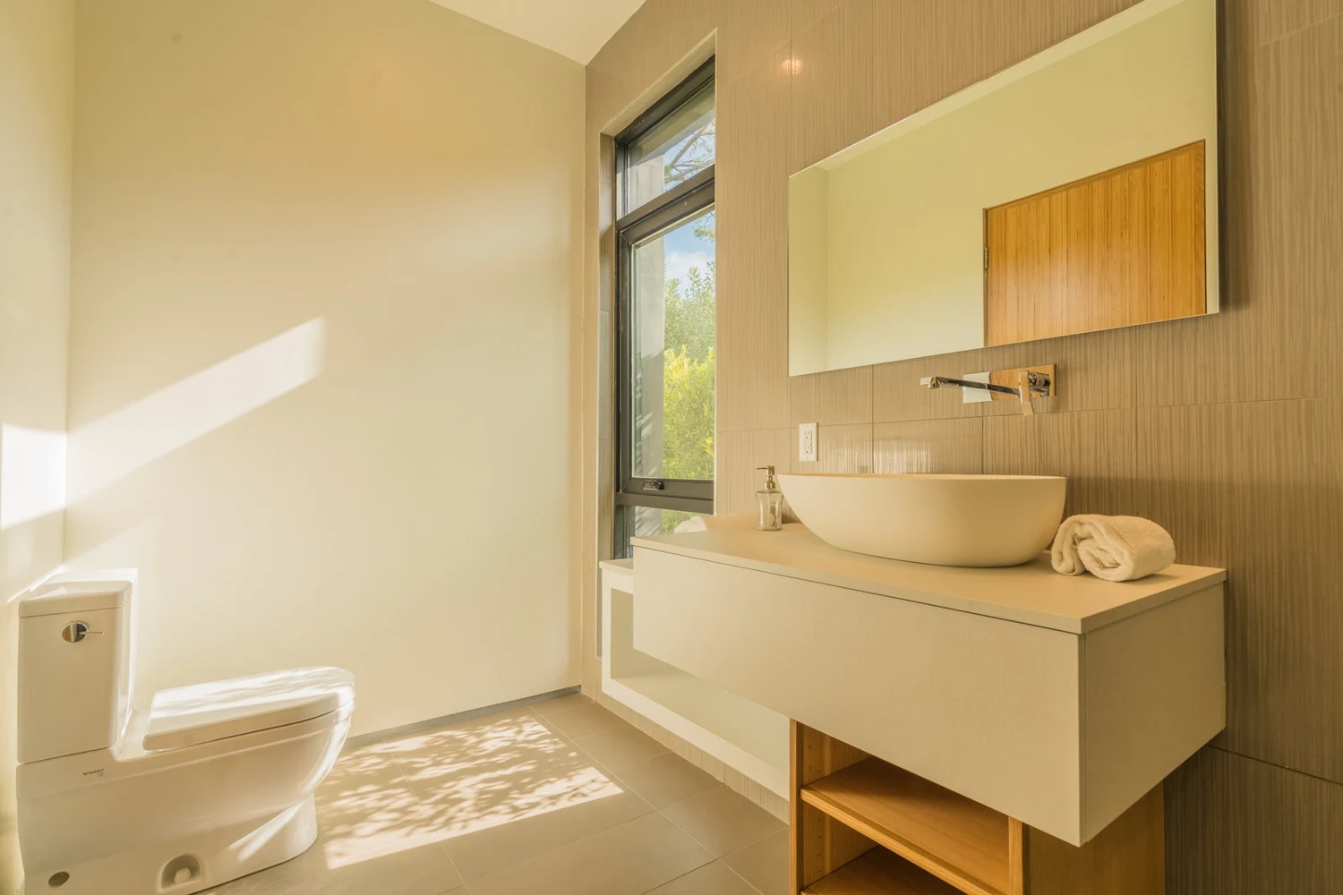 Bathroom surfaces paired with a floating vanity. — Villa Escondite